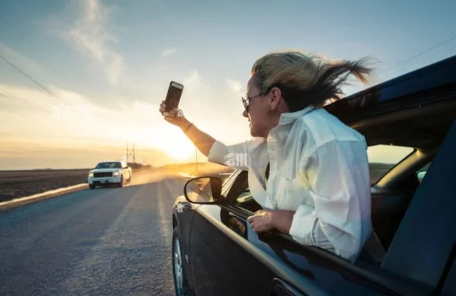 Tesla Cybertruck Why Hasn't Tesla Fixed the Combo Turn Signal & Backup Camera? woman-making-selfie-out-of-the-car-window-on-the-road-at-sunset-J06MXG (1)