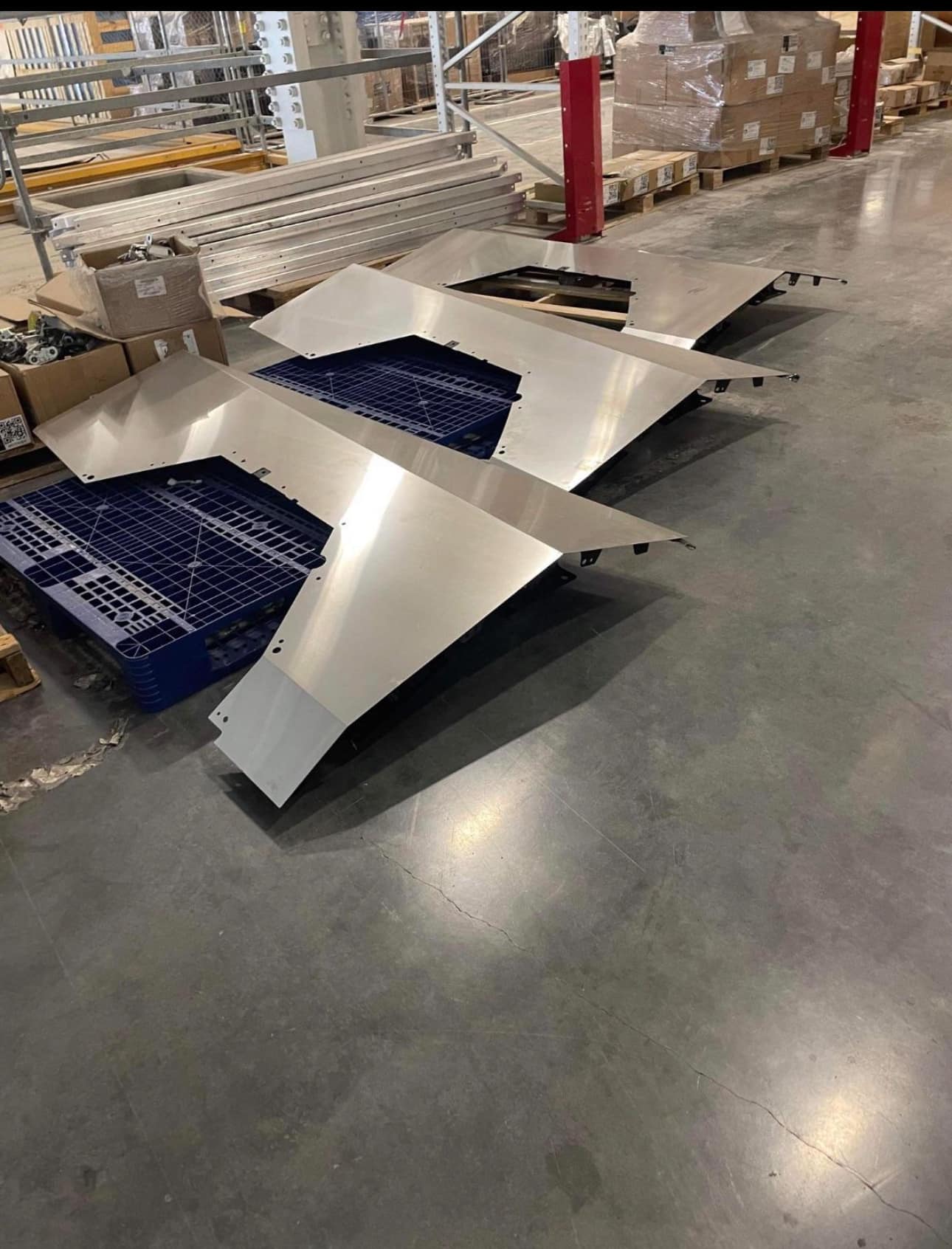 Tesla Cybertruck Unassembled fender quarter panels stainless steel parts on Giga Texas factory floor 1696452277859