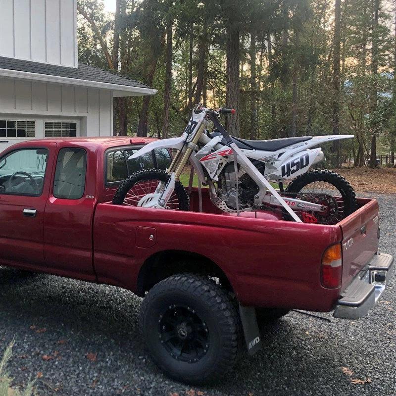 Tesla Cybertruck Cybertruck hauling big motorcycle (Honda Adventure) in its bed 1698326563880