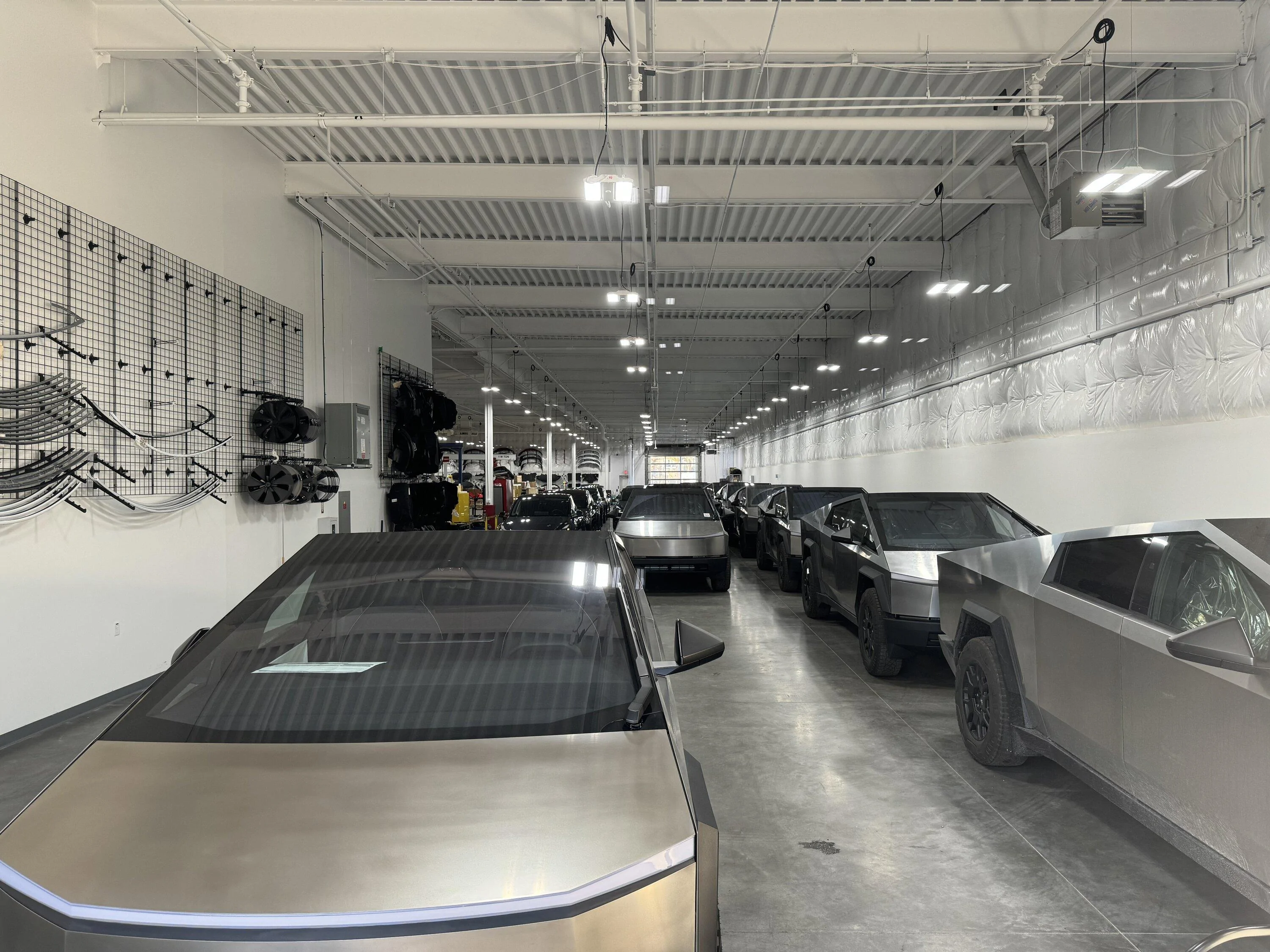 Tesla Cybertruck 12/28 Waiting Room My CT delivered 6-Mar on left - Six CTs parked on right against the wall possibly for deliver