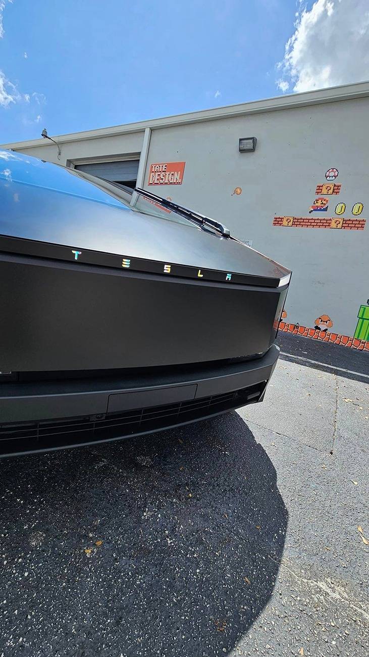 Tesla Cybertruck Black Cybertruck w/ blacked out (vinyl) front DRL light bar Tesla letters + Cyberbeast logo on tail lights Black Cybertruck w: blacked out (vinyl) front light bar & tinted rear light bar. Cyberbeast lo