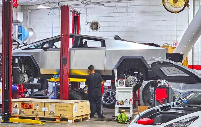 Cybertruck suspension & brakes exposed on a lift (photos 9/16/23)