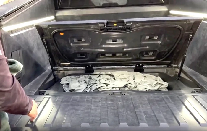 Cybertruck bed fully exposed w/ look at storage compartment cubby and LED lighting